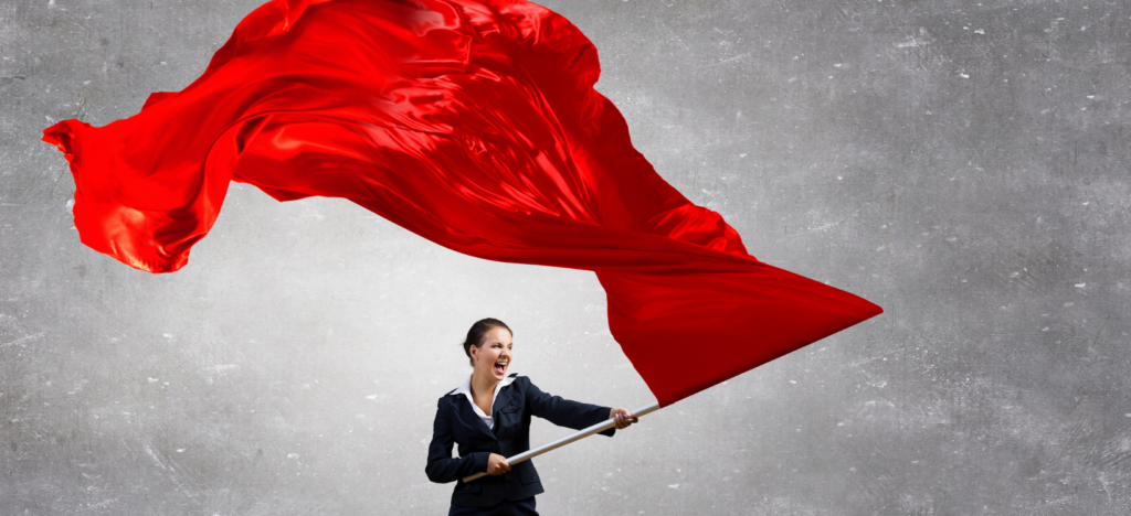 Woman in a black business suit waves red flag